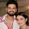 Shresta Iyer poses with a smiling Shreyas Iyer in a warmly lit restaurant setting.