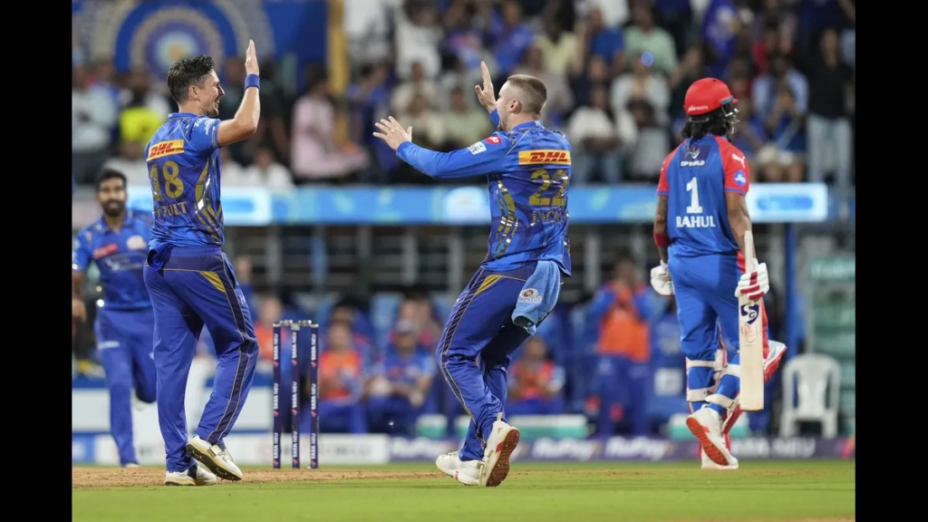 Mumbai Indians qualify for playoffs celebration as two players in blue jerseys high-five after taking a wicket during IPL match