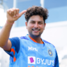 Kuldeep Yadav smiling and giving a thumbs-up while wearing the Indian cricket team training jersey during a practice session.